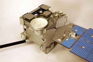 GOES satellite model close-up showing foil-wrapped bus, white sensor dish, mesh panels and solar array wing