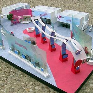 Trade show booth model seen from above, with red walkway, curved arch on red pillars and frosted display walls