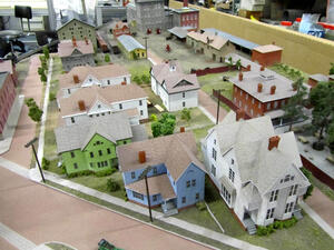 Genesee Brewery museum diorama by KiwiMill, overhead view of painted Victorian houses along a street toward the brewery