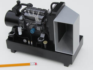 Diesel generator scale model on black skid base, angled front view with radiator duct and a pencil for size