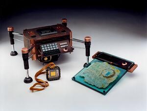 Science fiction movie prop set: copper-textured communication device on four legs, chip pendant and map on green acrylic