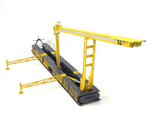 Land rig catwalk model with yellow lifting arm raised above its dark gray base and outrigger stands extended