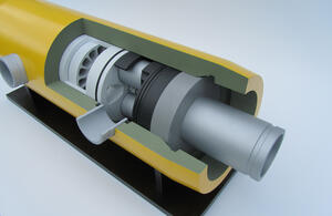 Close-up of cutaway turbine model showing vaned rotor, shaft components and seals inside a yellow housing
