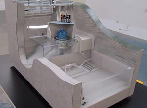 Hydroelectric dam working model in section view, blue generator above clear acrylic water channels and spillway