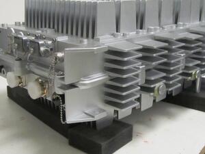 Radio communications scale model with cast resin cooling fins and RF connectors, resting on black foam blocks