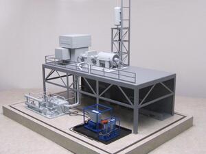 Lubrication system model on a display base, with grey platform-mounted machinery and blue-framed skids in front