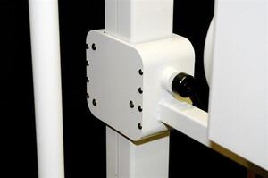 Medical wall stand close-up of the white joint housing with a screwed cover plate and a black locking knob on the arm