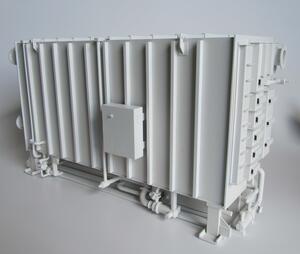 Steam chiller scale model in all-white finish, side view showing ribbed shell, control box and piping along the base