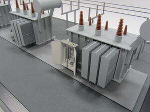 Power transformer model close-up with weatherproof enclosure doors open beside radiator fins and brown bushings