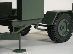 Radar trailer model close-up of olive green chassis, fender, knobby off-road tire and leveling jack foot