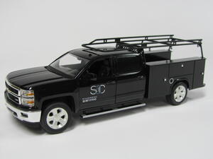 KiwiMill custom truck model in black with utility service body and ladder rack, shown from the front three-quarter view
