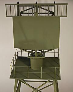 Fixed tower radar model with olive drab antenna panel above a railed platform and cylindrical rotating pedestal