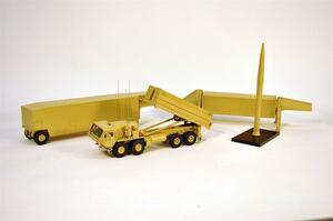 THAAD missile launcher model set with launcher truck, raised launcher, two trailers and a missile on a black stand