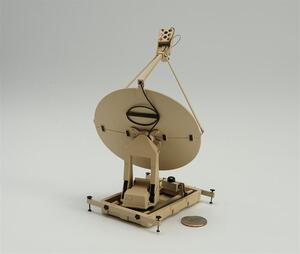 Satellite dish scale model seen from behind, tan dish on mount and base frame with leveling feet, coin for scale