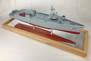 LUSV boat model raised on metal posts over a mirrored oak base, seen from the bow quarter with its hull reflected below