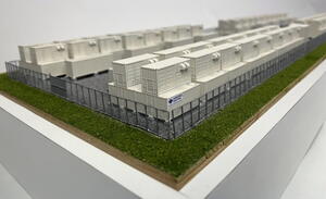 Redox flow battery scale model corner view showing stacked white battery containers behind a gray perimeter fence