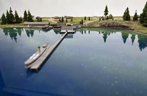 Lake Tahoe historical model cover shot: low view across resin water to a steamboat at a long pier and lakeshore town