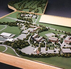 Architectural massing model of a college campus master plan, angled aerial view with trees, roads and parking lots