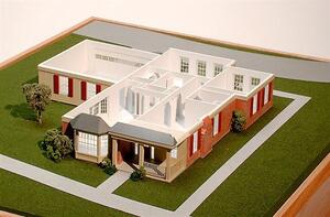 Retirement cottage architectural model with roof lifted off, showing interior room layout, brick walls and front porch