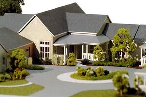 Retirement cottage architectural model with gray roofs, a covered front porch and a landscaped circular drive with trees