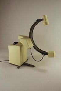 C-arm X-ray scale model in three-quarter view, showing cream base column, dark gray C-arm and T-shaped floor stand