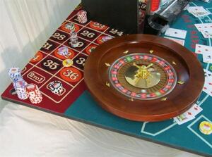 Casino display corner with roulette wheel, numbered roulette felt, poker chip stacks and blackjack cards