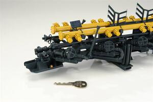 Manifold trailer model front end with yellow flanged pipes, dark valve handwheels and solar panel, key shown for scale