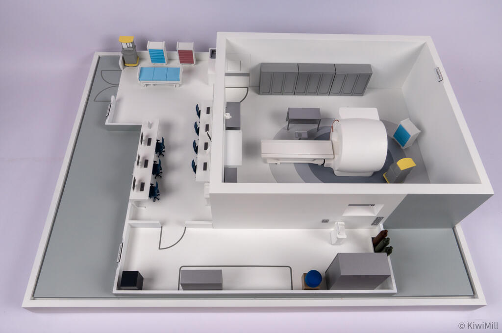 Overhead view of the suite from the opposite side, with the equipment room and its gray cabinets in the foreground