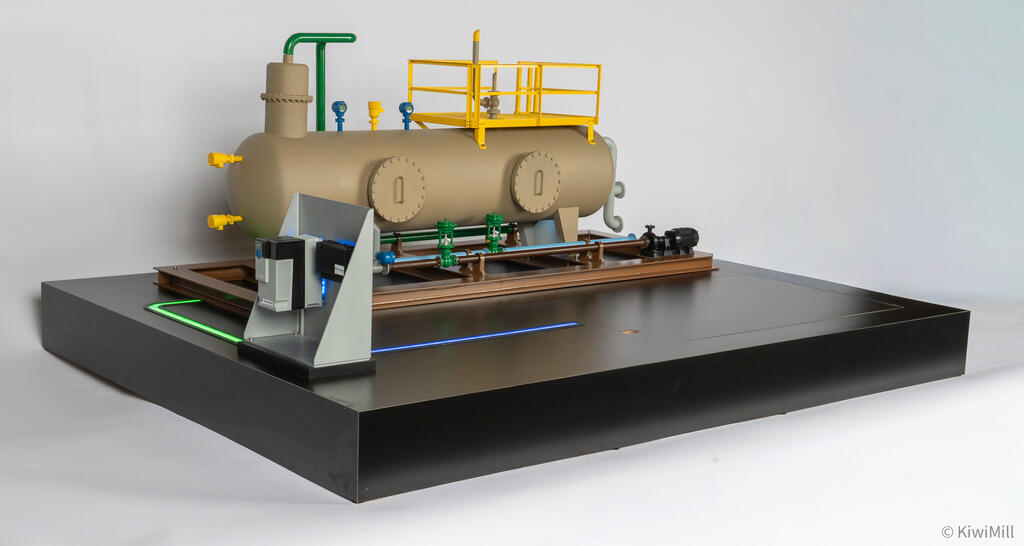Low side angle of the separator skid model with automation devices on the angled gray stand in the foreground