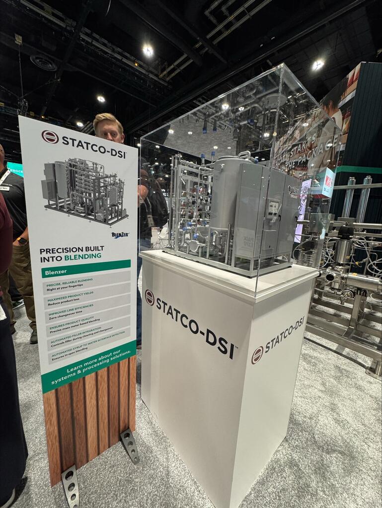 Statco-DSI display pedestal with the acrylic-covered BlenZer model beside a product sign at a trade show