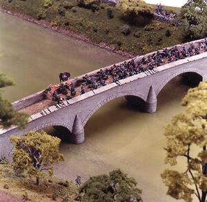 Burnsides Bridge diorama close-up: stone arch bridge crowded with blue-uniformed soldier figures and flags over river